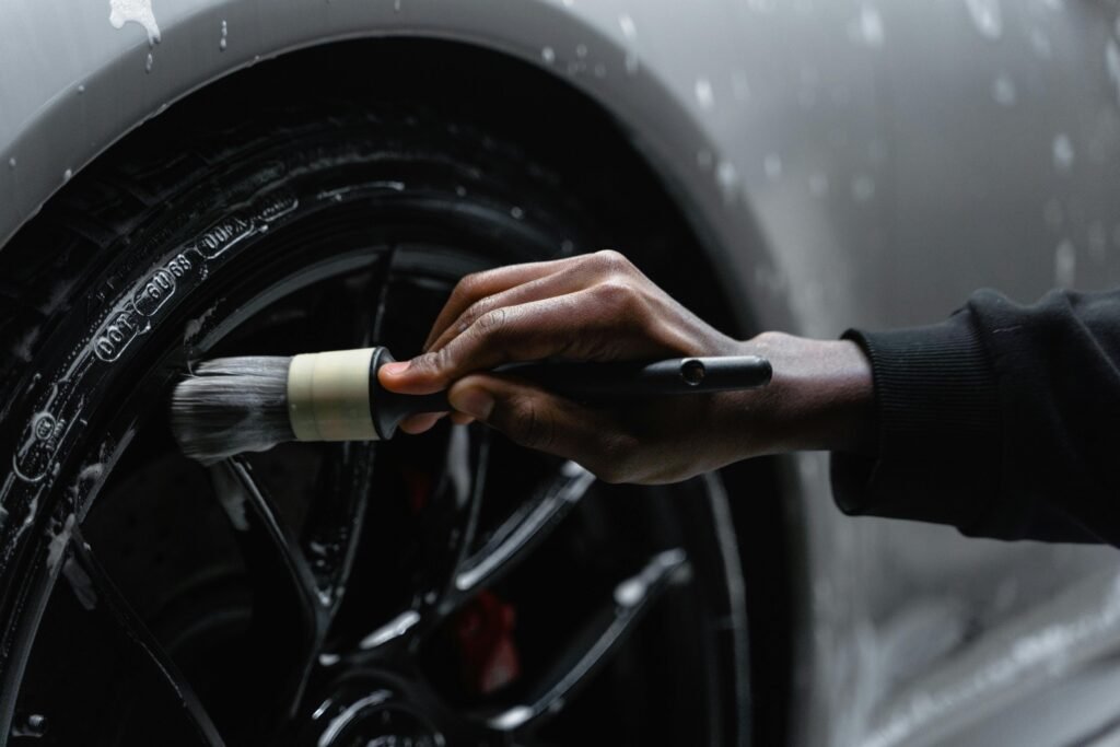 pexels photo 6872175 6872175 A detail-oriented close-up of a hand cleaning a car tire with a brush and soap.